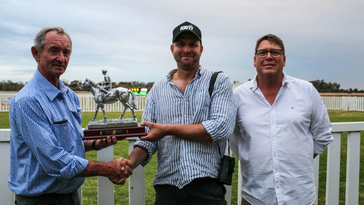 Anthony Axtill presents the Leeton Soldiers Club Stan Axtill Memorial Trophy to Wangaratta trainer Craig Weeding with Leeton Jockey Club president Grant Fitzsimon in attendance. Picture courtesy Kim Woods