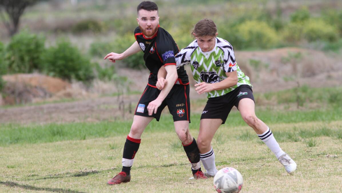 BATTLE LINES: Leeton United's Jaxon Brody fights for possession of the ball over his South Wagga opponent on Sunday afternoon. Photo: Talia Pattison